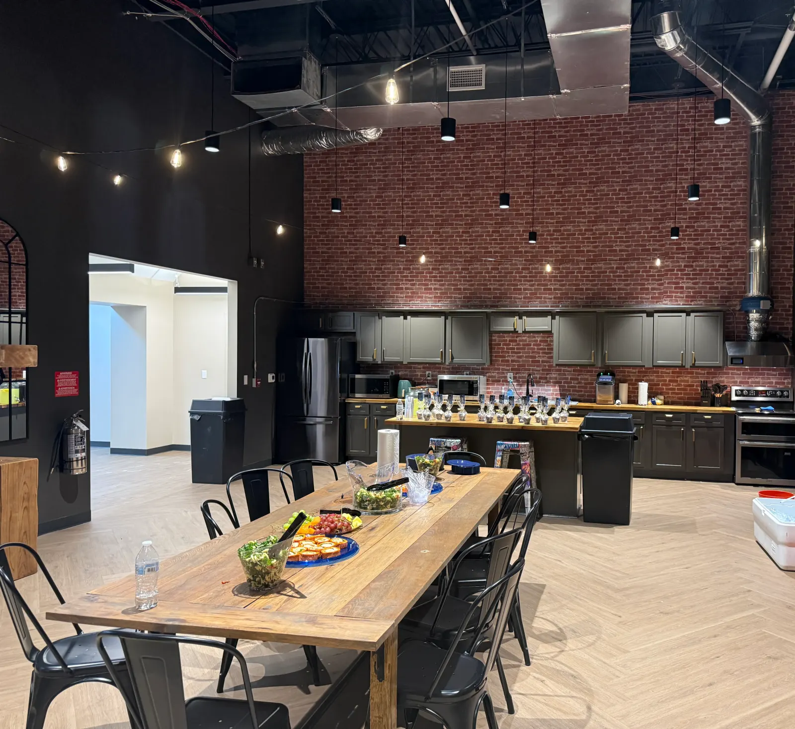 Bistro-style break room and coffee bar with a long wood table at Redeemers Structural Solutions.