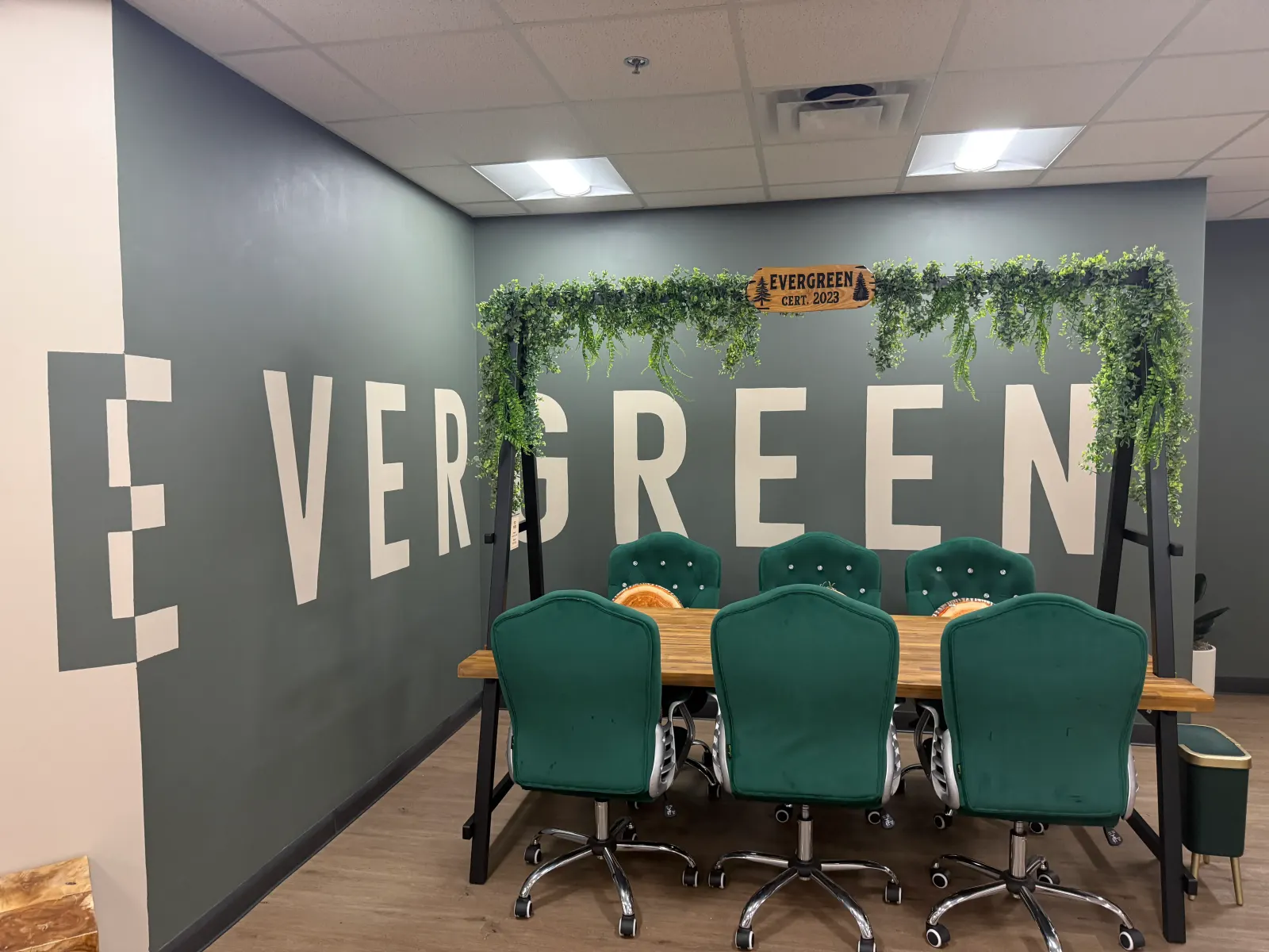 Evergreen conference room at Redeemers Structural Solutions with green chairs and the company's Tugboat Institute Evergreen plaque.