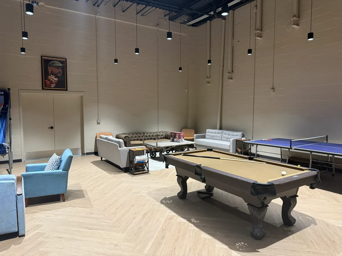 Game room with a pool table, ping pong table, and lounge seating.